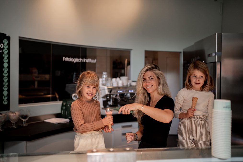 Moeder met twee dochters en ijsjes in de winkel