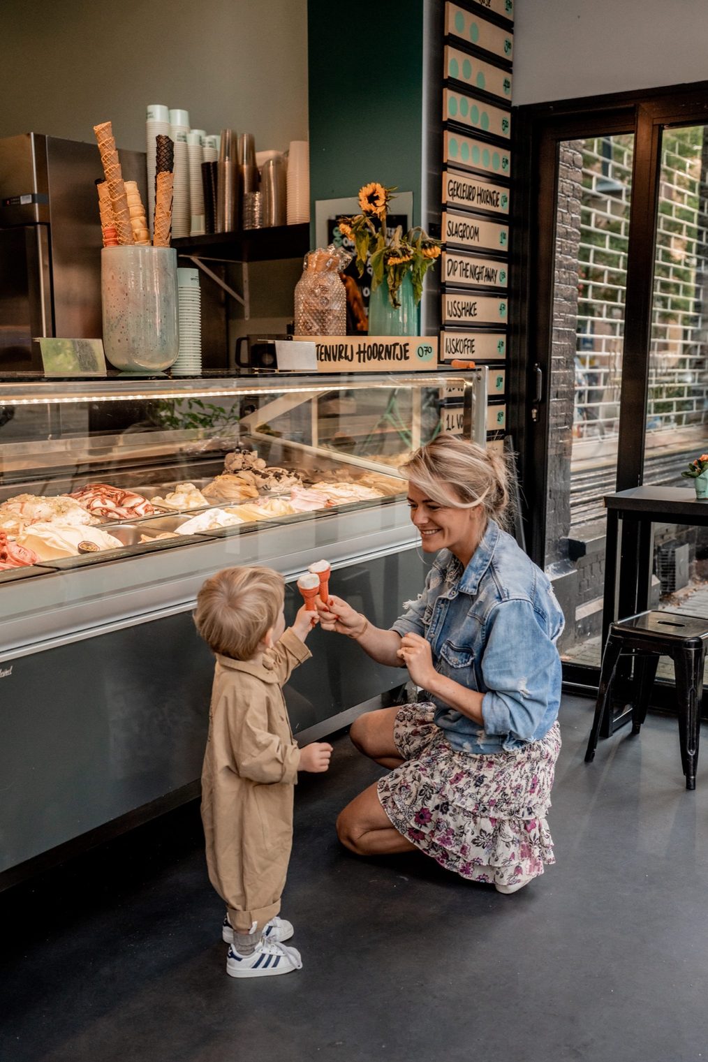 Een kind krijgt een ijsje bij de vitrine