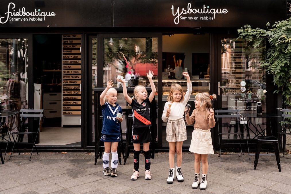 Juichende kinderen voor de winkel in Oud-Zuid